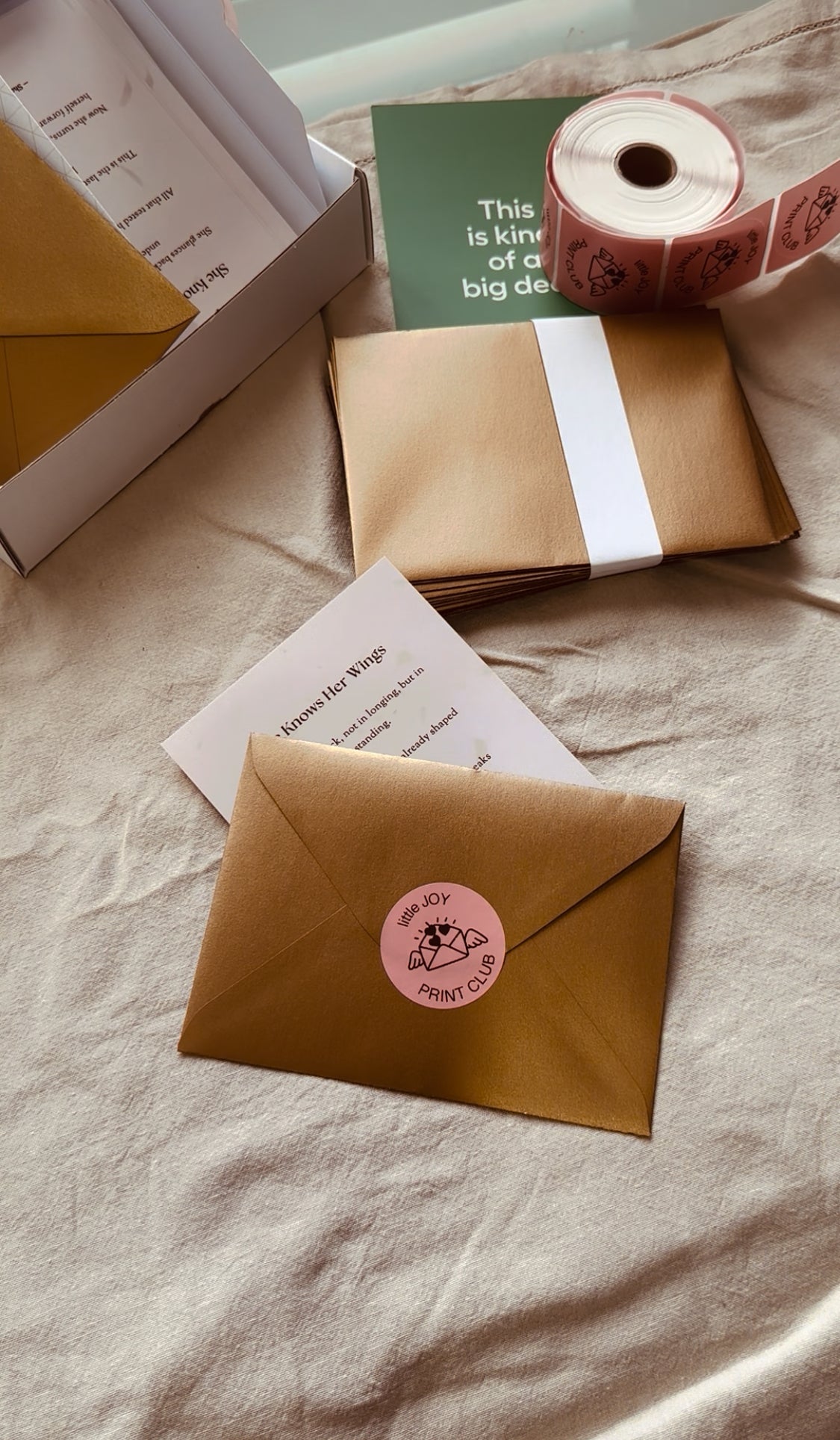 Brown envelopes with pink stickers on a light fabric background
