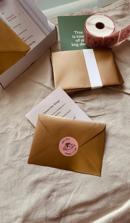 Brown envelopes with pink stickers on a light fabric background
